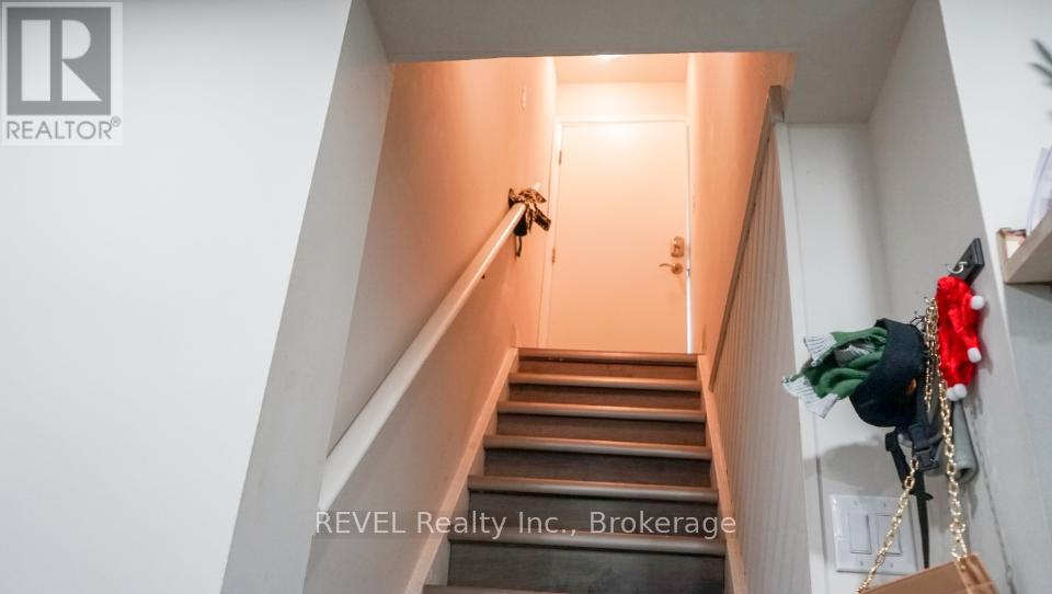 A staircase with a light at the top and a plant on the side.