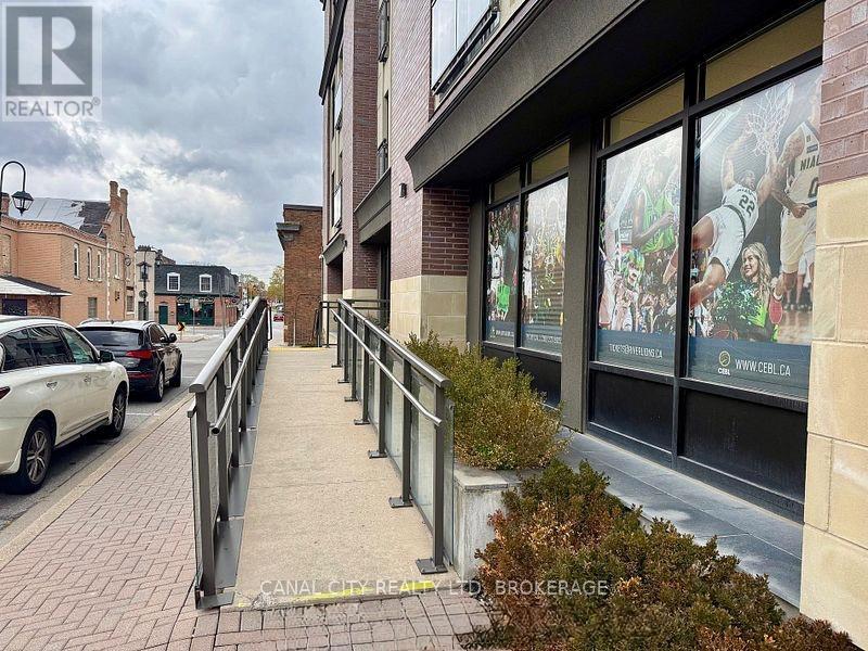 A street view with a realtor sign on the building.