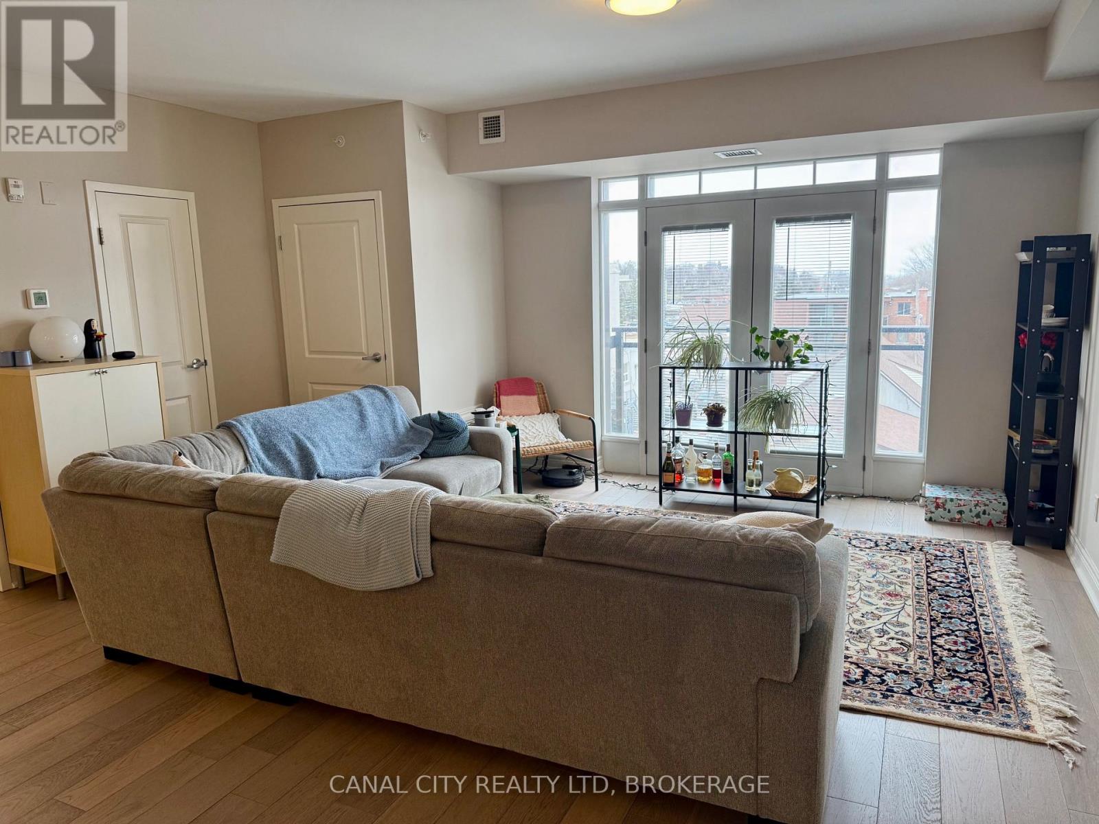 A bedroom with a bed, a couch, and a window with a view of the city.