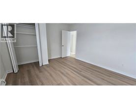 A bedroom with a white door and a wooden floor.