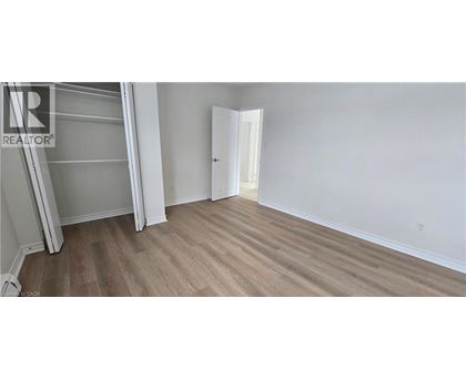 A bedroom with a white door and a wooden floor.