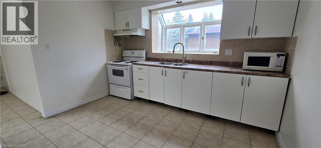 A kitchen with white cabinets and appliances.