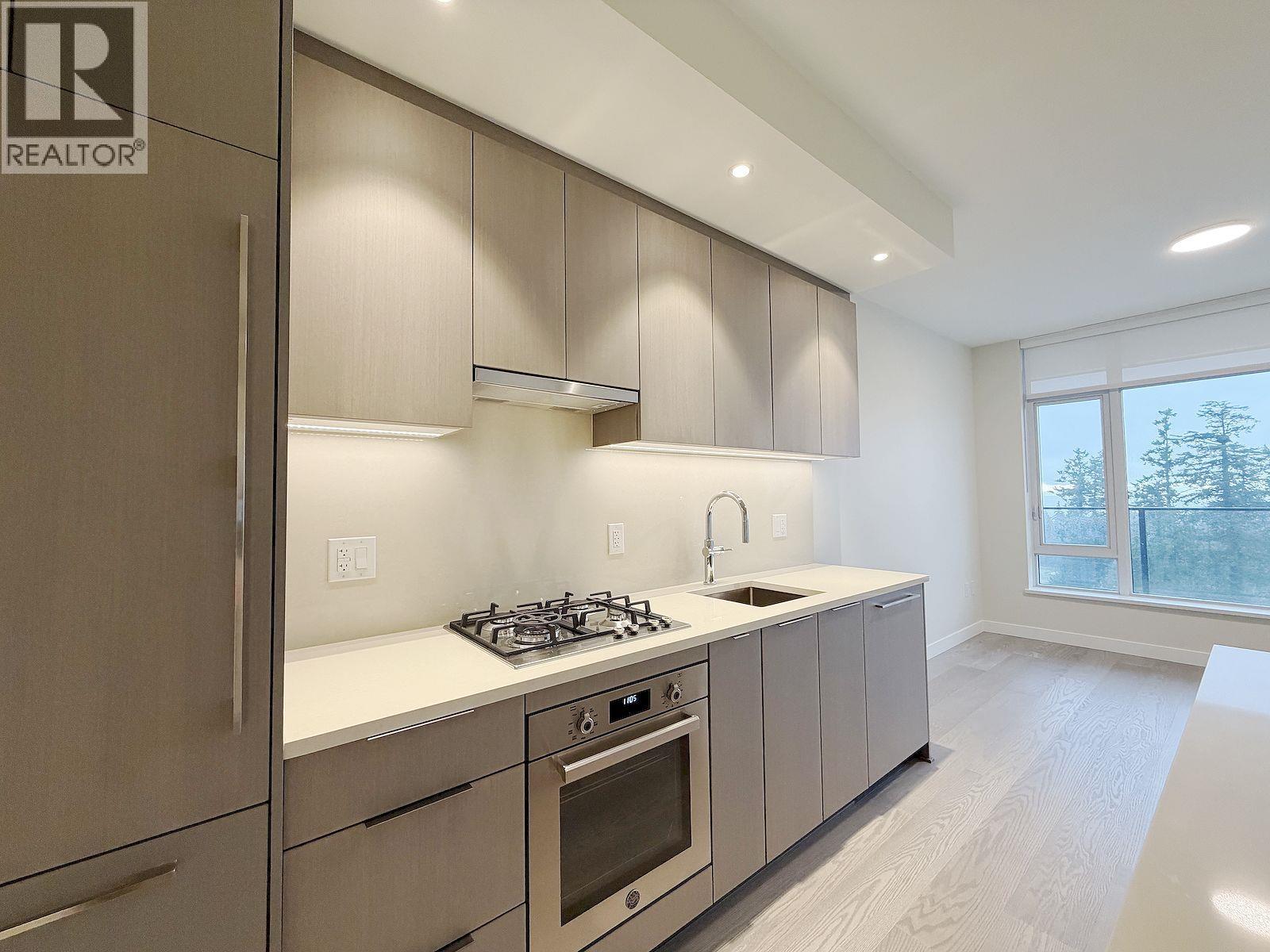 A modern kitchen with a stove top oven and a sink.