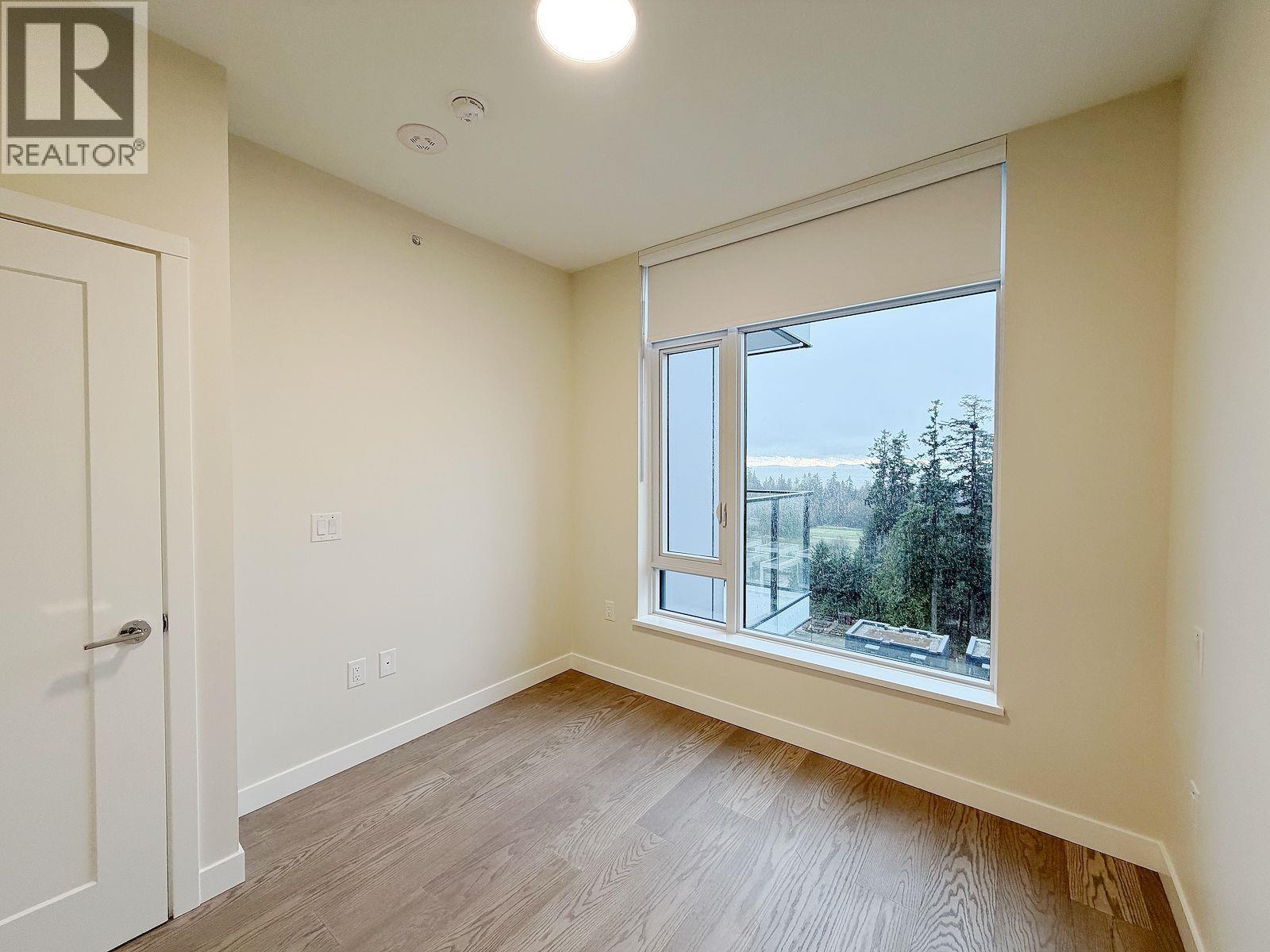 A wood and white walk in closet with shelves.