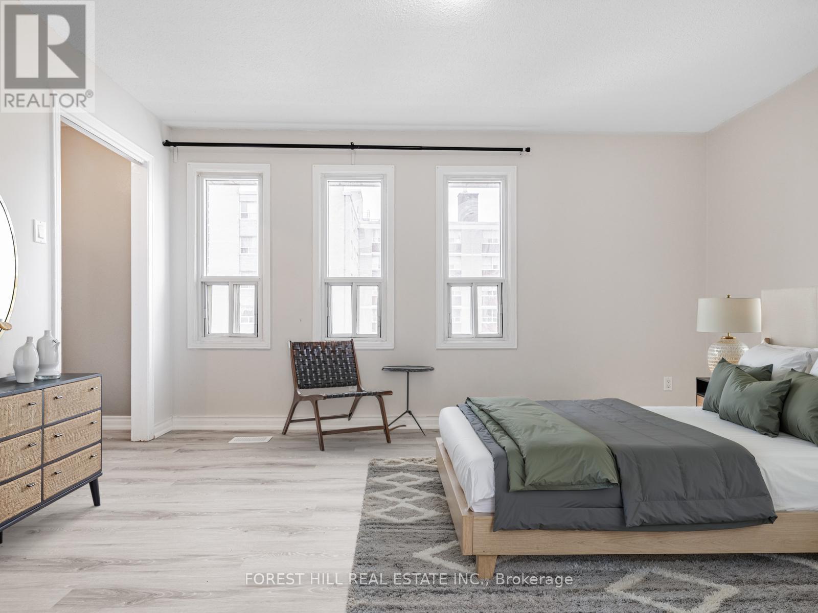 A bedroom with a bed, chair, and a dresser.