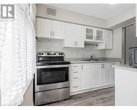 A kitchen with a stove top oven and white cabinets.