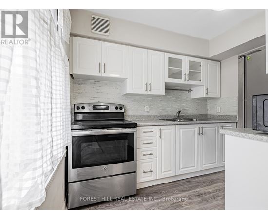 A kitchen with a stove top oven and white cabinets.