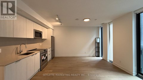 A kitchen with white cabinets and a microwave above the stove.