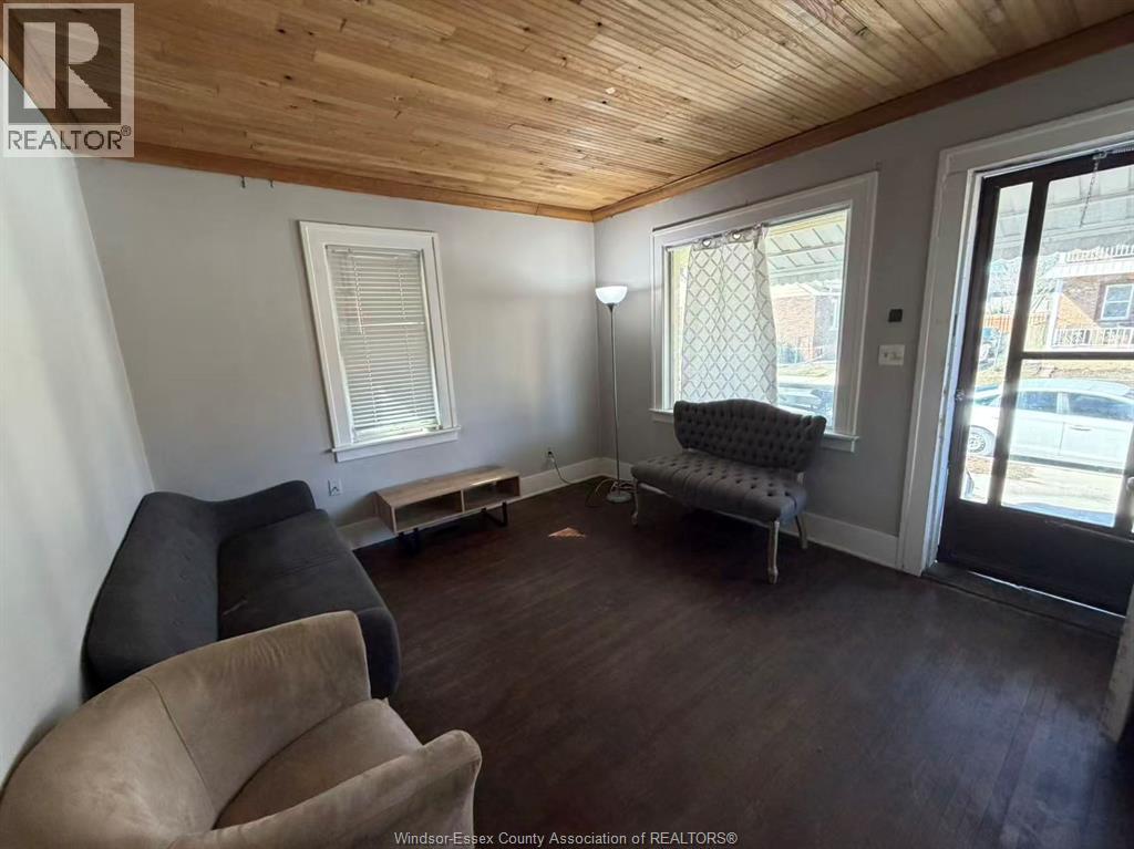 A living room with a couch, chair, and sliding glass doors.