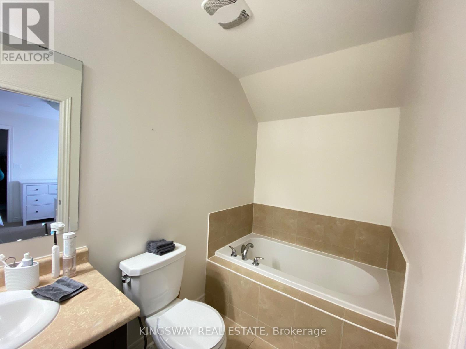 A white toilet sits next to a sink in a small bathroom.