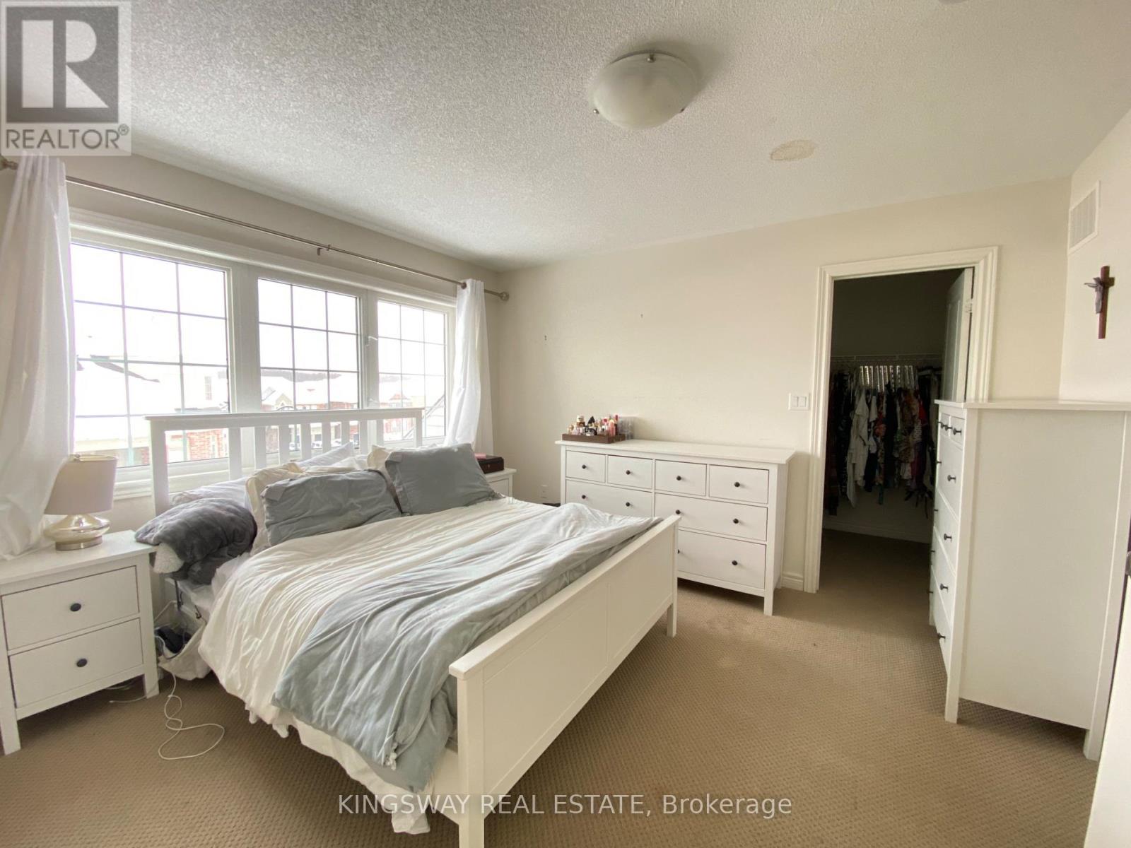 A bedroom with a bed, nightstand, and closet.
