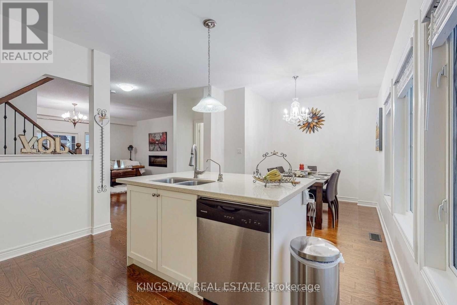 A kitchen with a stainless steel dishwasher and a white countertop.