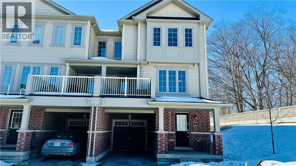 A two-story house with a balcony and a car parked in the driveway.