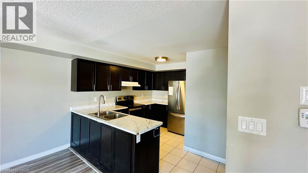 A kitchen with black cabinets and a marble countertop.