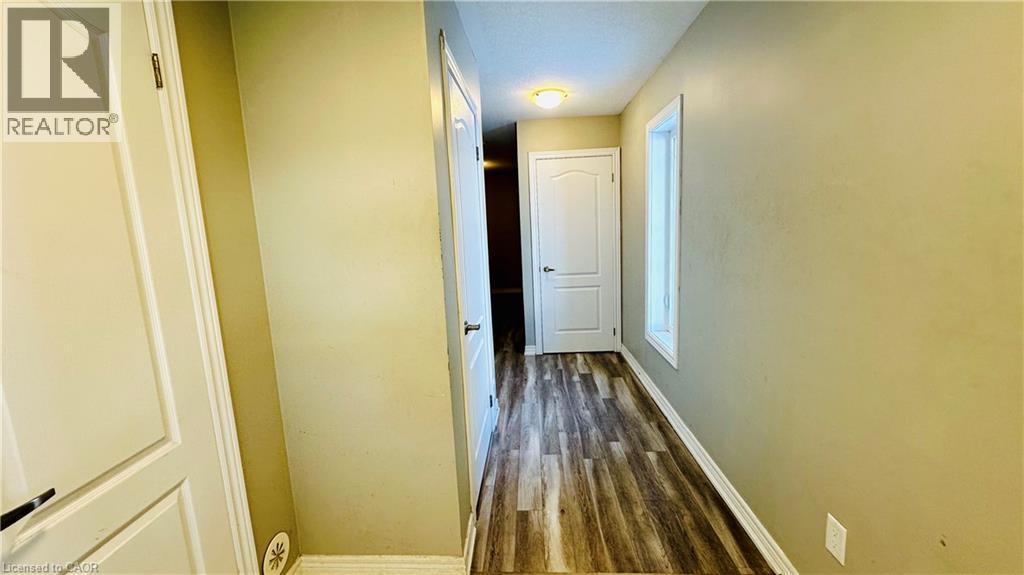A hallway with a white door and wooden floors.