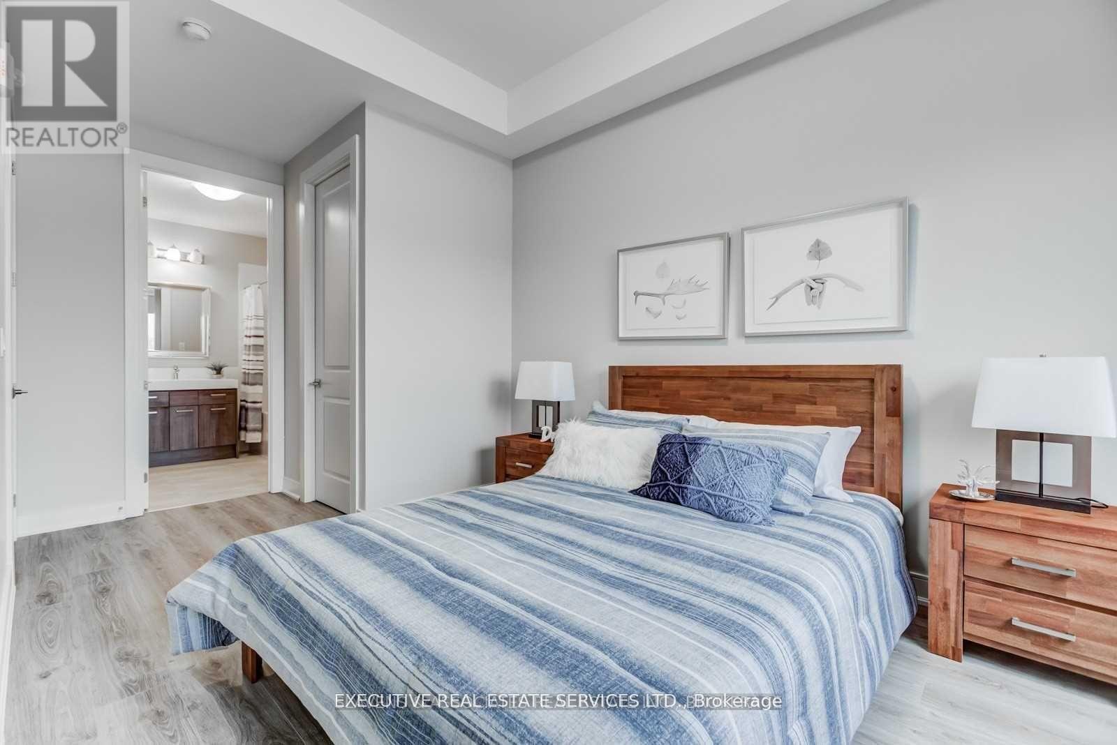 A bedroom with a bed, nightstands, and a painting on the wall.