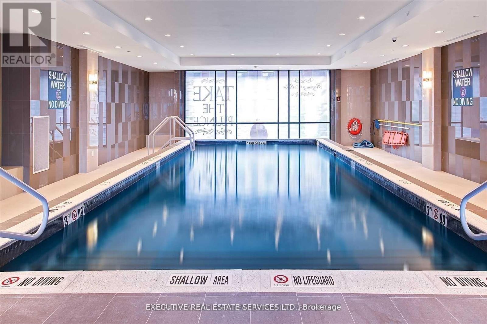 A large indoor swimming pool with a shallow area and no lifeguard.