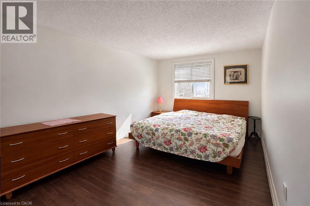 A bedroom with a bed, dresser, and window.