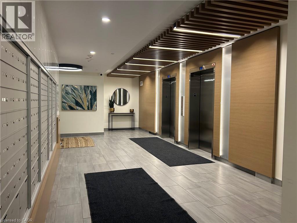 A hallway with a wooden ceiling and a black and white rug on the floor.