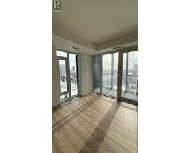 A room with wooden floors and large windows overlooking a cityscape.