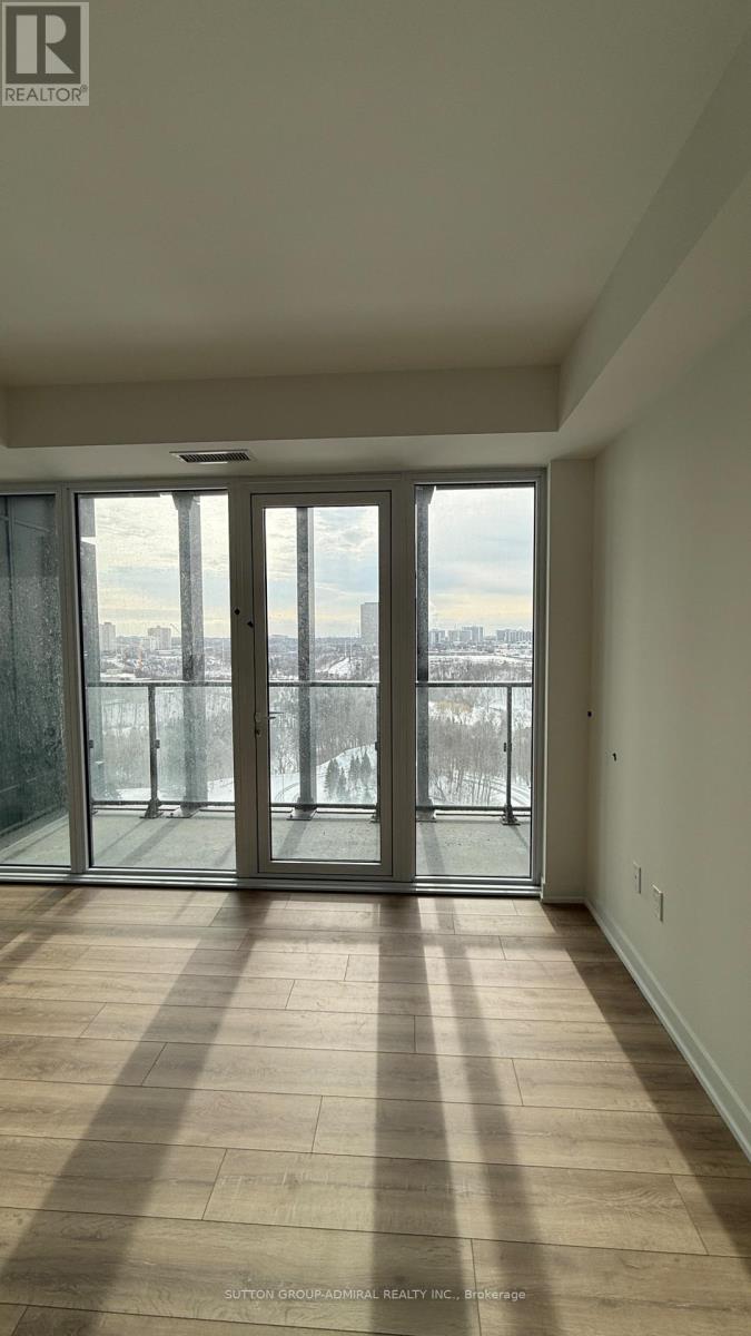 A large empty room with a view of the city through a glass door.