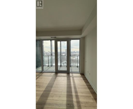 A large empty room with a view of the city through a glass door.