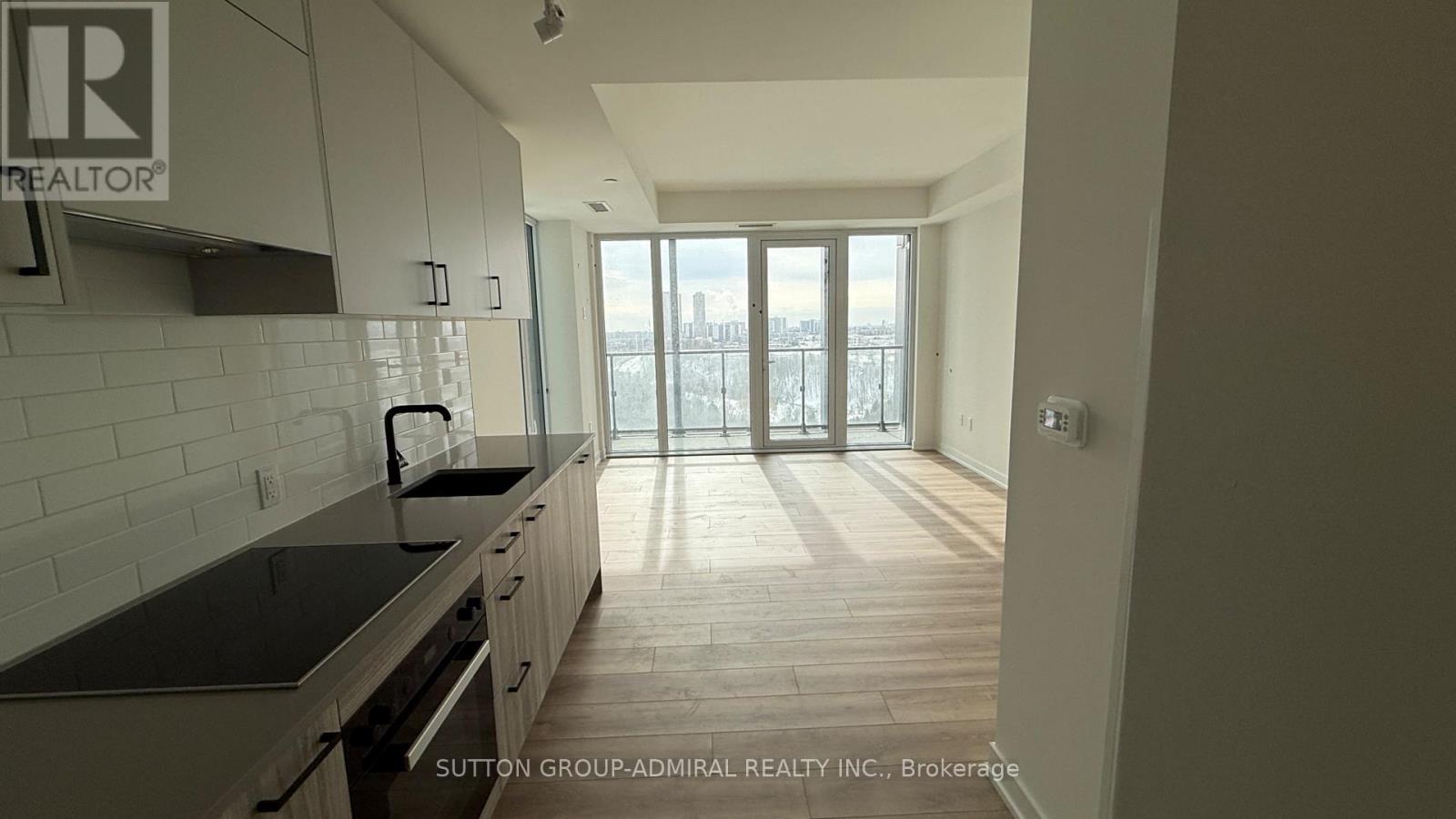 A kitchen with a view of the city through the windows.