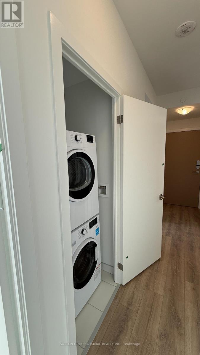 A white door opens to a laundry room with a washer and dryer.