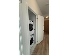 A white door opens to a laundry room with a washer and dryer.