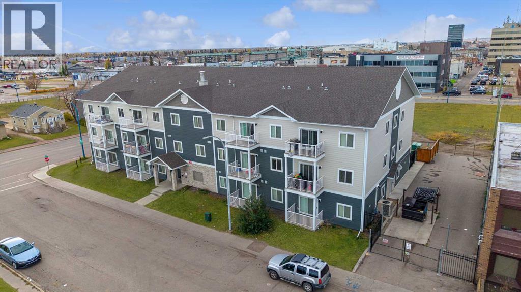 A large apartment complex with a parking lot in front.