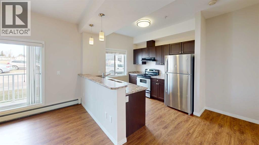 A kitchen with a refrigerator, stove, and oven.