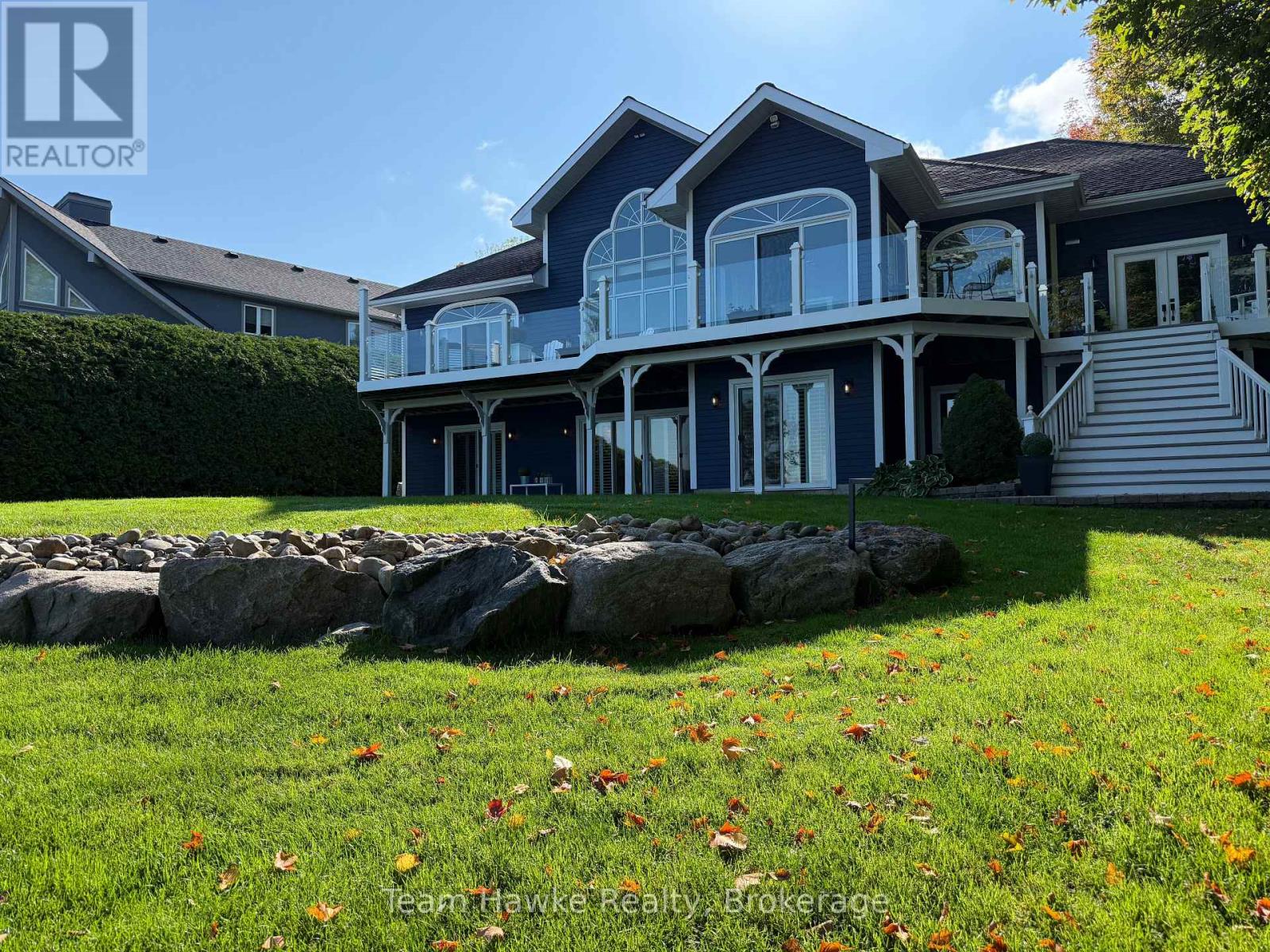 A house with a stone wall in front of it.