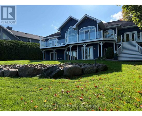A house with a stone wall in front of it.