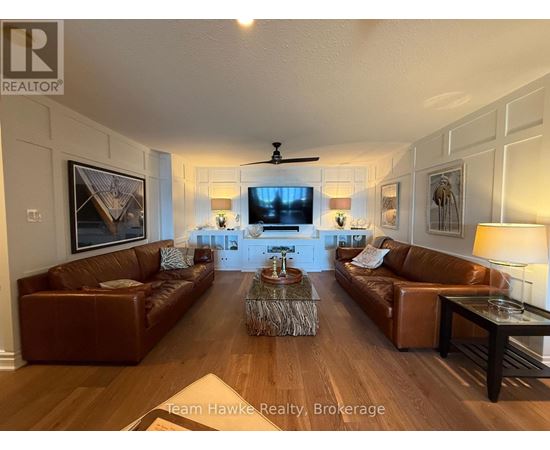 A living room with brown leather couches and a wooden floor.