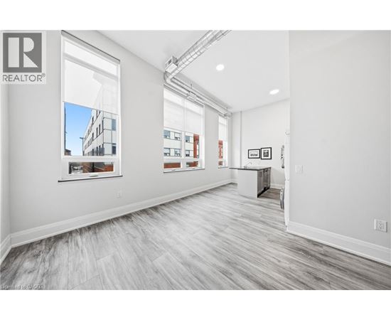 A spacious room with a large window and a view of a building outside.