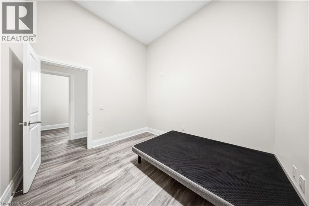 A bedroom with a bed, a door, and a window.