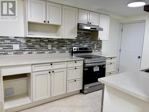 A kitchen with white cabinets and a stone backsplash.