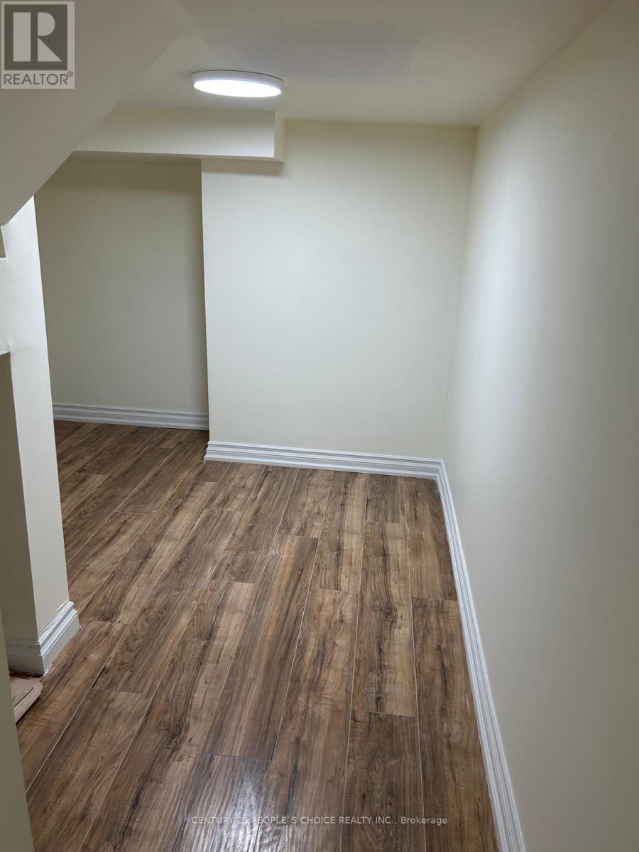 A room with wooden flooring and white walls.