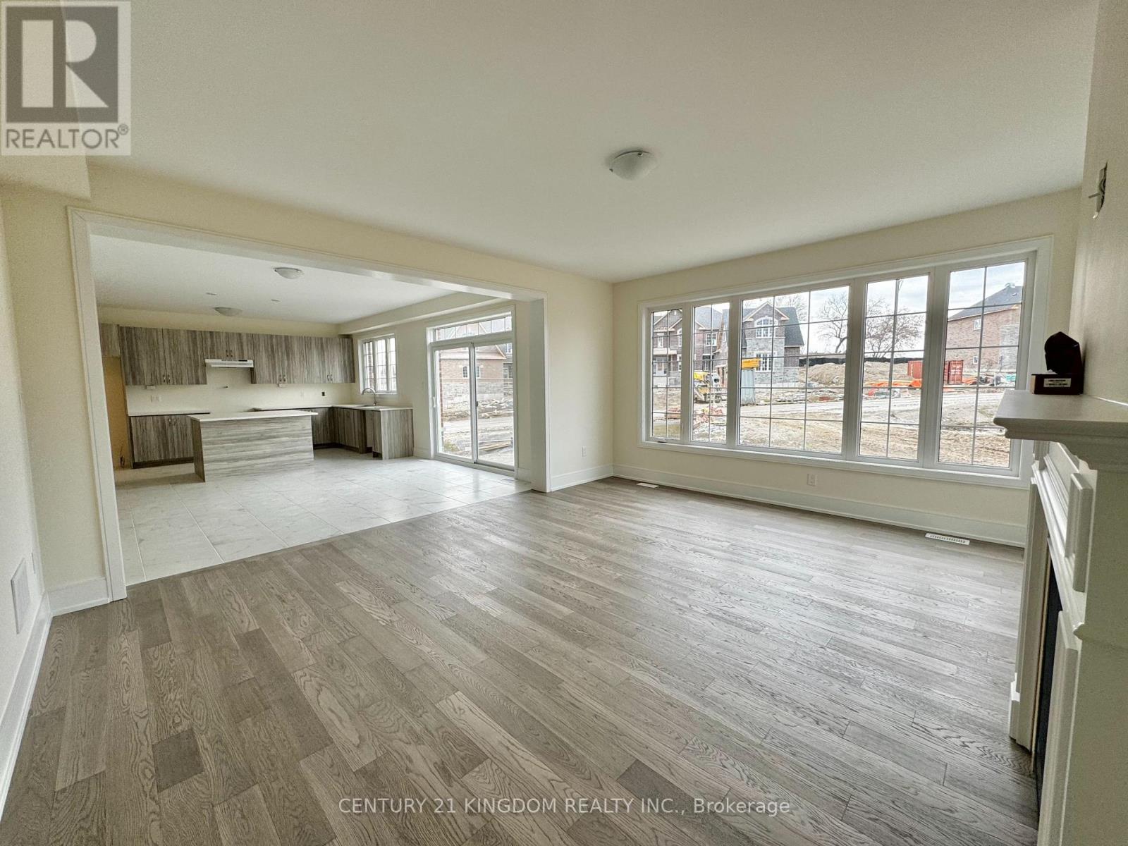 A spacious living room with wood flooring and large windows.