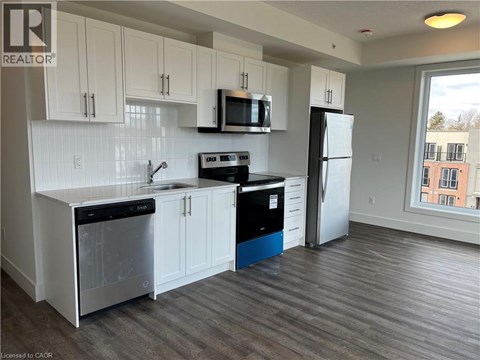 A kitchen with white cabinets and a black stove top oven.