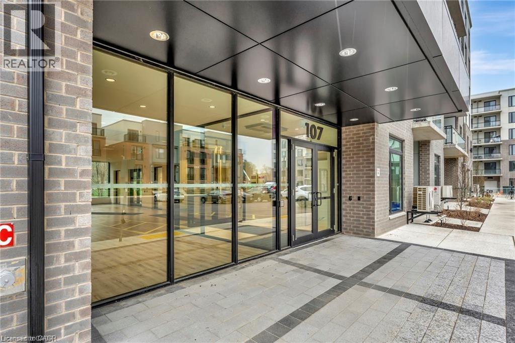 The image shows the front of a building with the number 107 on it and a glass door entrance.