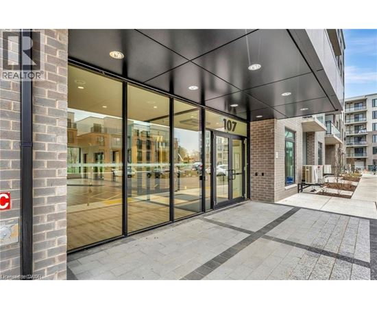 The image shows the front of a building with the number 107 on it and a glass door entrance.