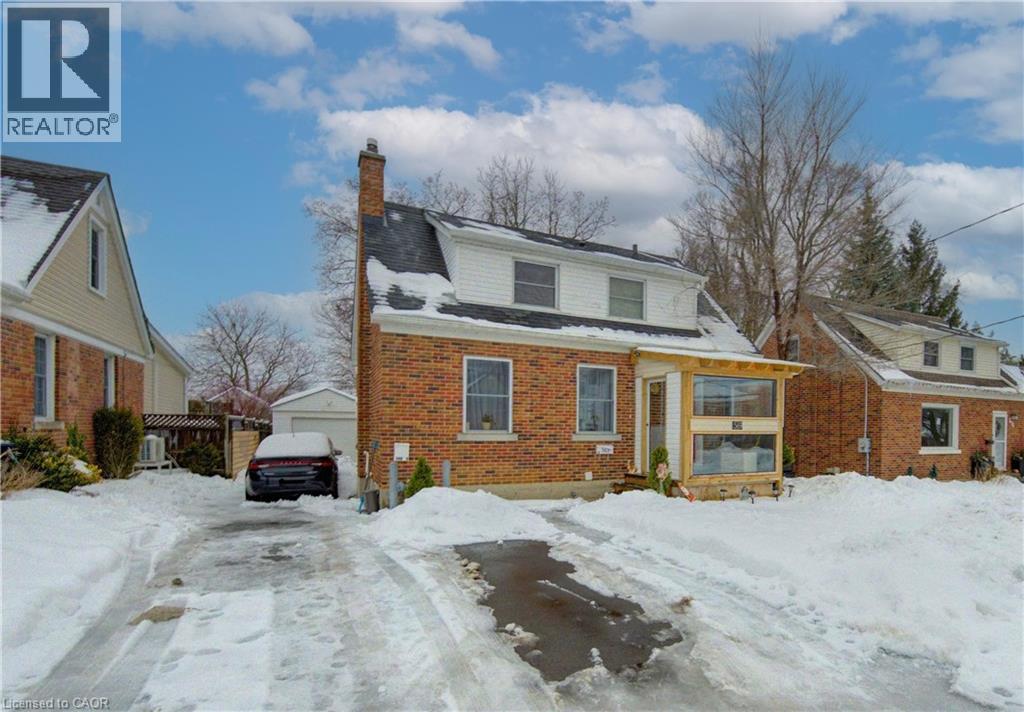A house with a snow-covered driveway in front.