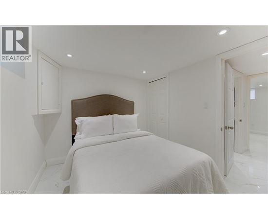 A bedroom with a large bed and a white bedspread.