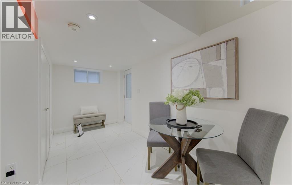 A modern dining room with a glass table and grey chairs.