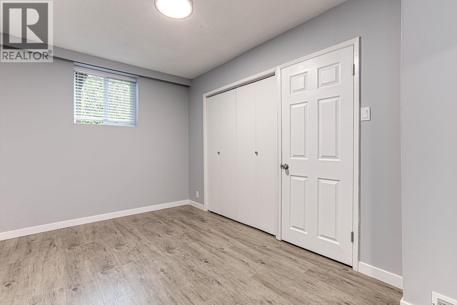A room with a white door and a window with blinds.