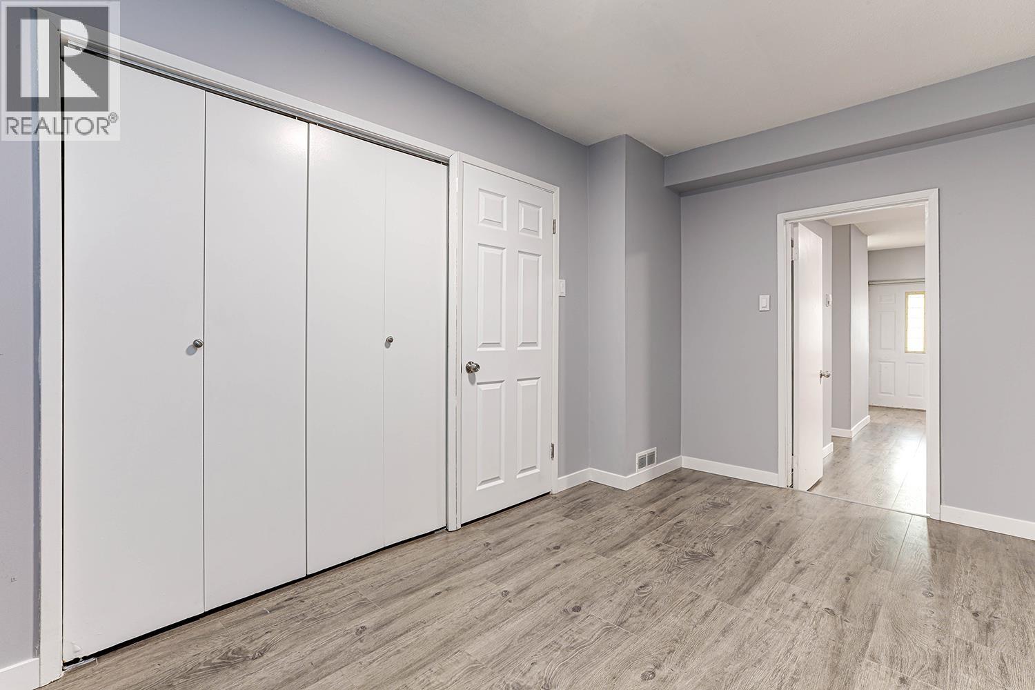 A room with a white door and a grey wall.