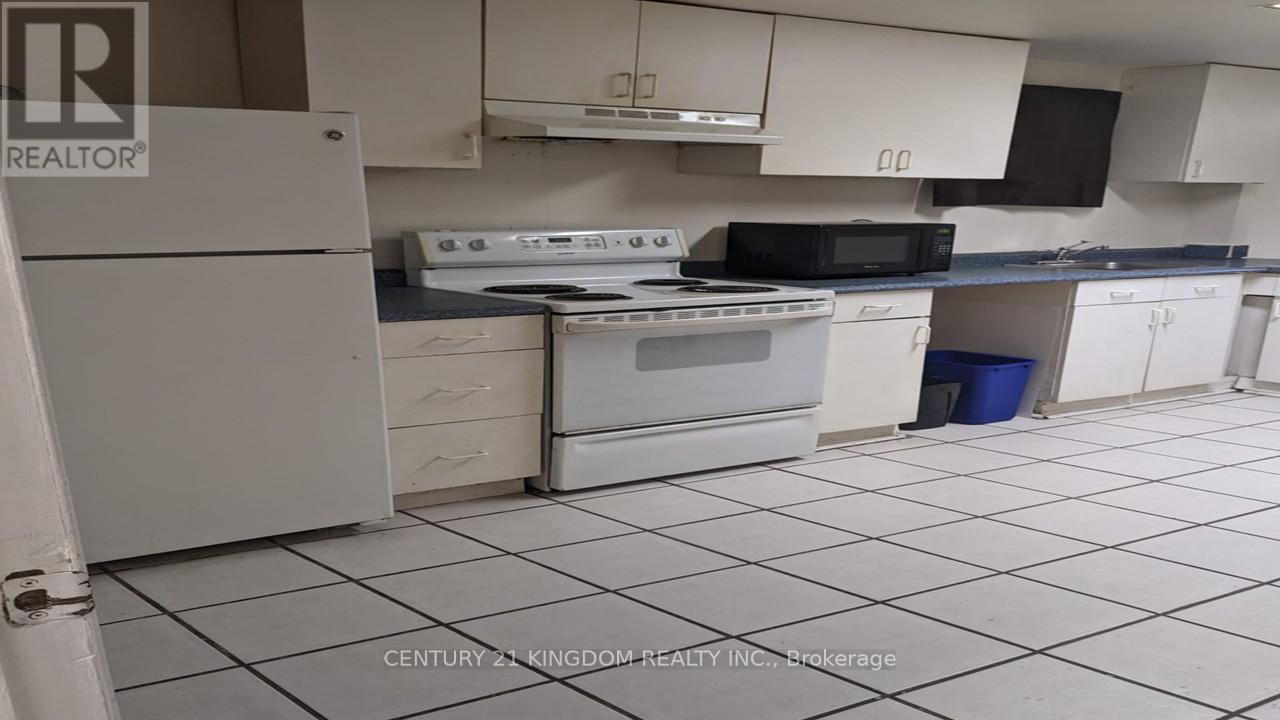 A kitchen with white appliances and black countertops.