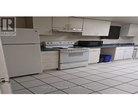 A kitchen with white appliances and black countertops.