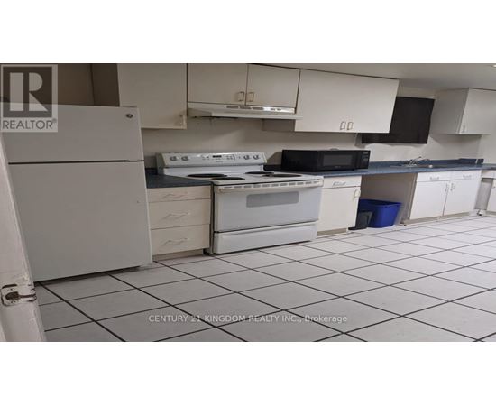 A kitchen with white appliances and black countertops.